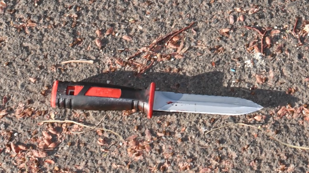 a knife with a black and orange handle