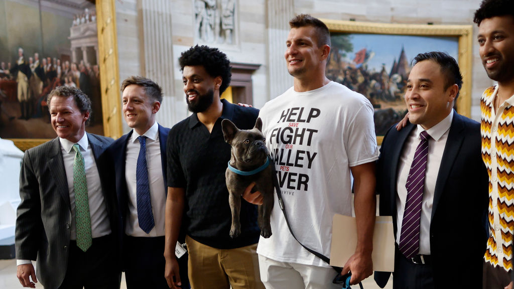 Four-time NFL Super Bowl champion Rob Gronkowski poses for photographs with his French bulldog Ralphie in the Rotunda of the U.S. Capitol. He wears a white t-shirt that says "help fight valley fever, save our pets"