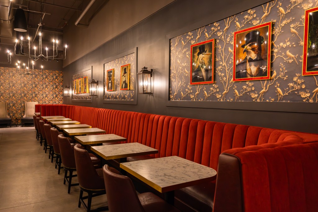 The long shotgun booth and tables at the bird themed-speakeasy, The Nightingale.