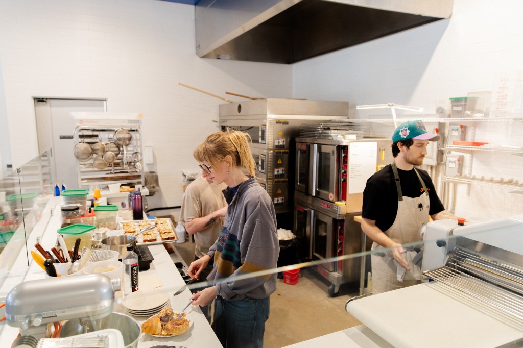 Three bakers work in the small open kitchen of Moxie Bakery.