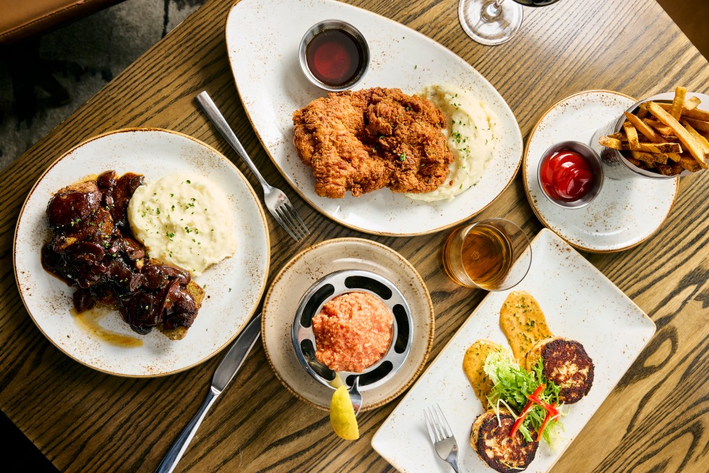 A table filled with entrees and appetizers from Harry & Izzy's.