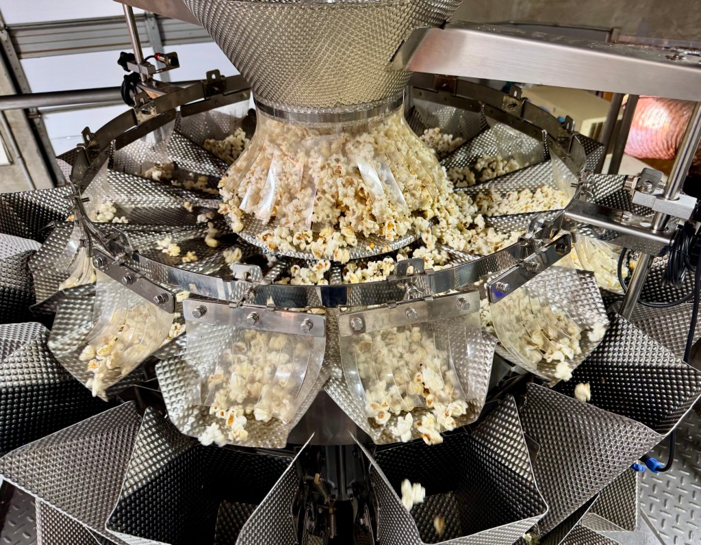 Popcorn gets dividing into shoots of a packaging machine.
