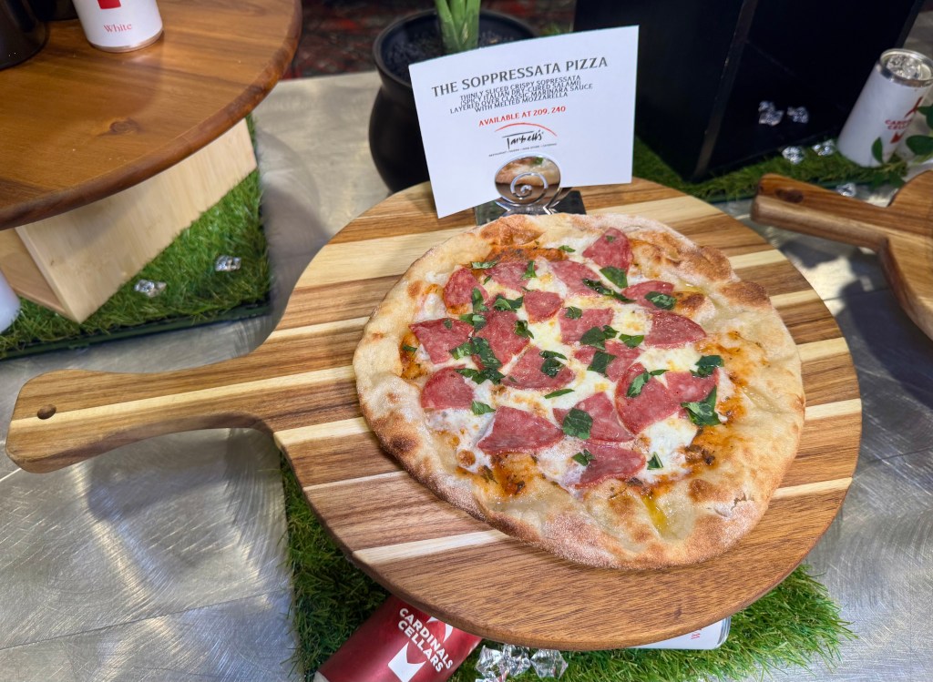 A soppressata pizza on a peel.