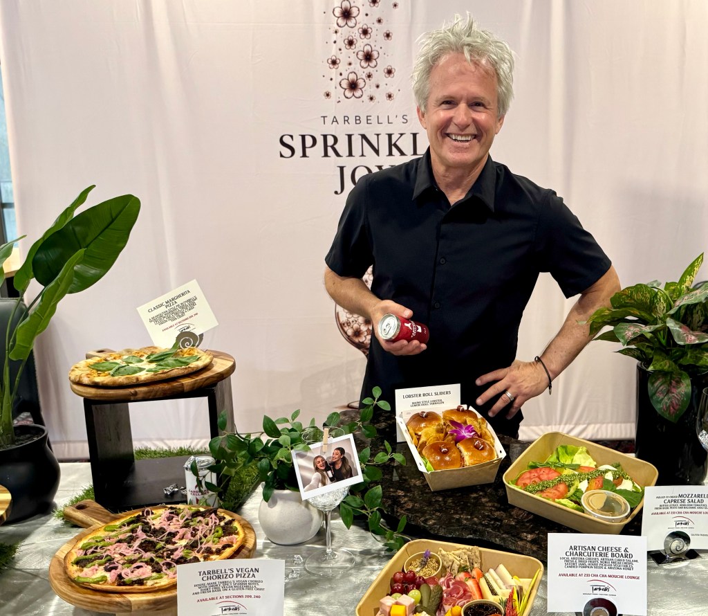 Chef and restaurateur Mark Tarbell poses in front of a spread of food at State Farm Stadium.