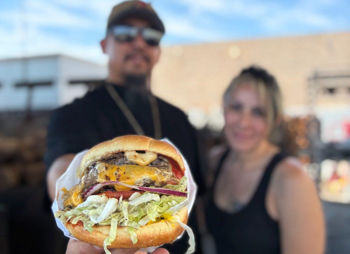 Army Ant's Cheeseburgers owner and chef Anthony Garcia and general manager Victoria Kays pose with a cheeseburger.