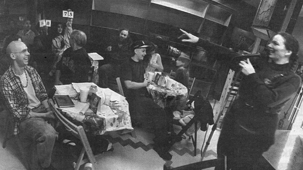 Mary McCann performs at a 1994 poetry slam at Beulah’s Deli in Phoenix as audience members watch.