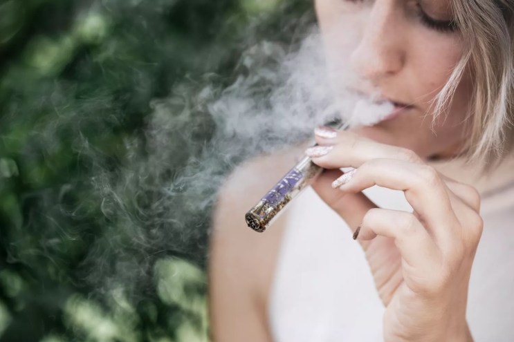 someone smoking weed out of a pipe