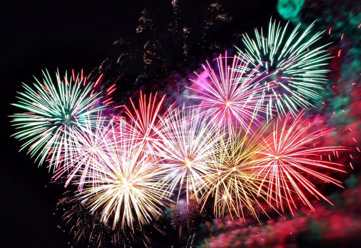 A series of colorful fireworks explode in the night sky.