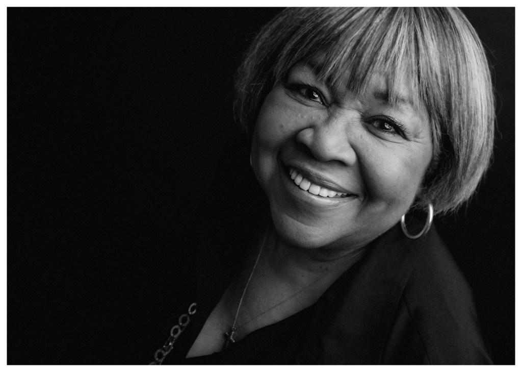 A black-and-white photo of a smiling African-American woman.