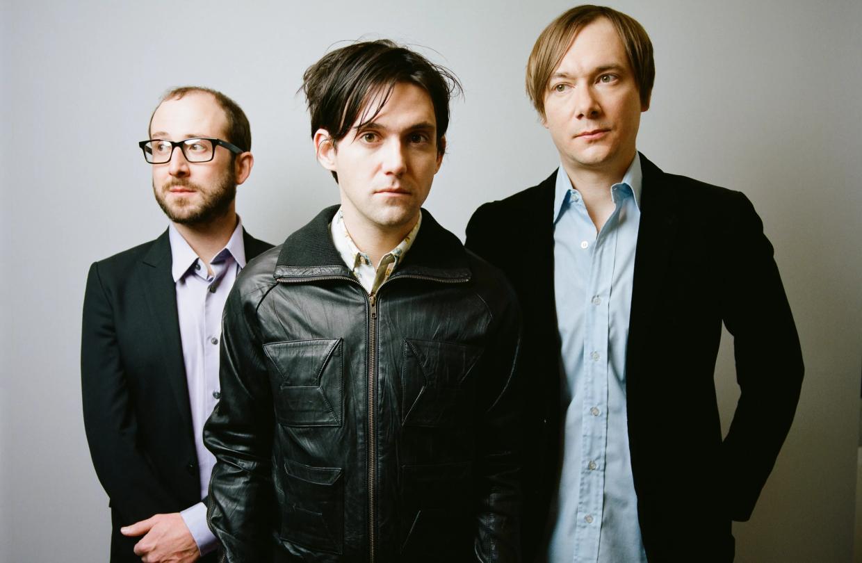 Three men posing for a picture.