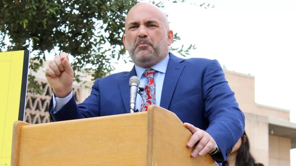 david chami gestures at a podium