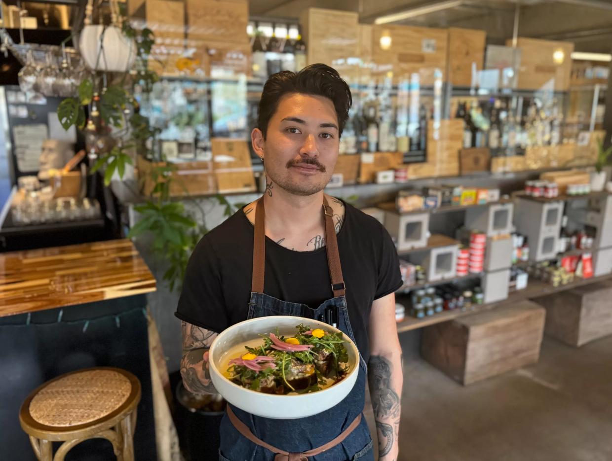 Chef Marco Di Santo holding a dish.