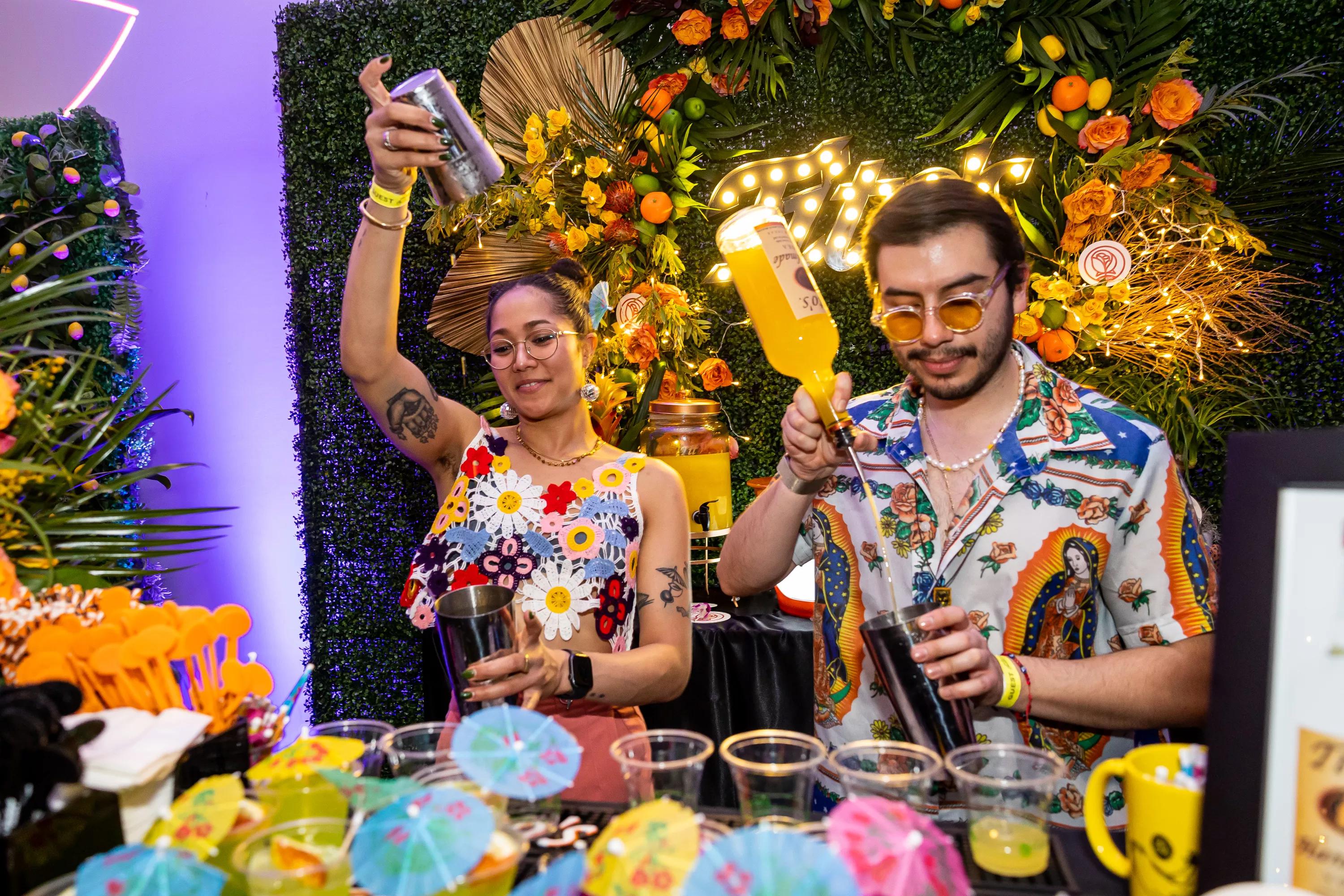 Two bartenders making drinks.