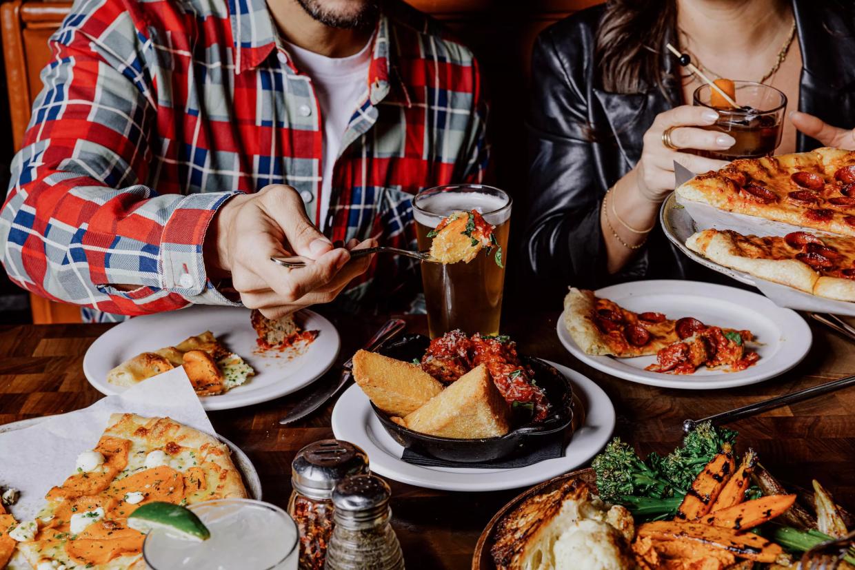 Digging in at a table full of food.