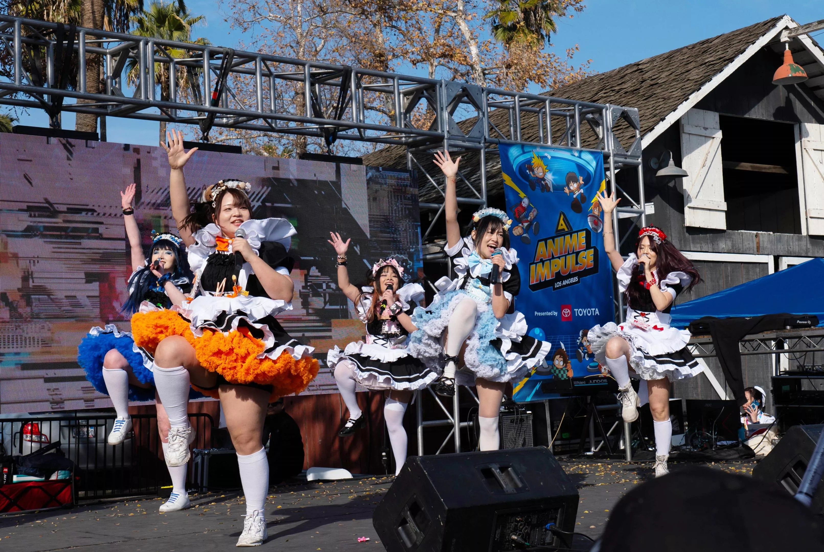Costumed anime performers onstage at a convention.