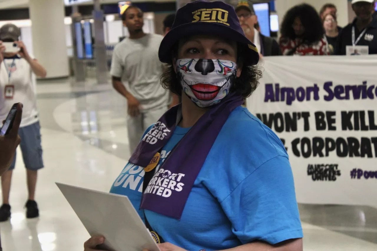 A woman in a blue shirt and dia de los muertos facemask