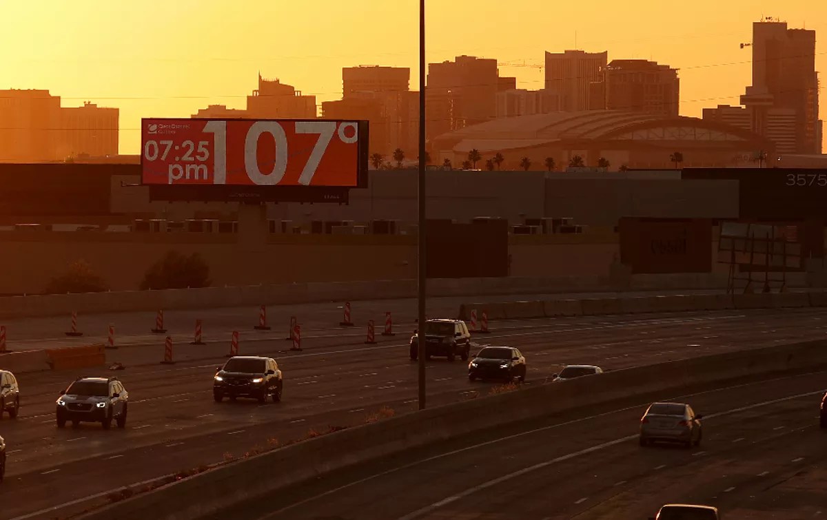 a phoenix highway with a billboard reading 107 degrees at 7:25 p.m.