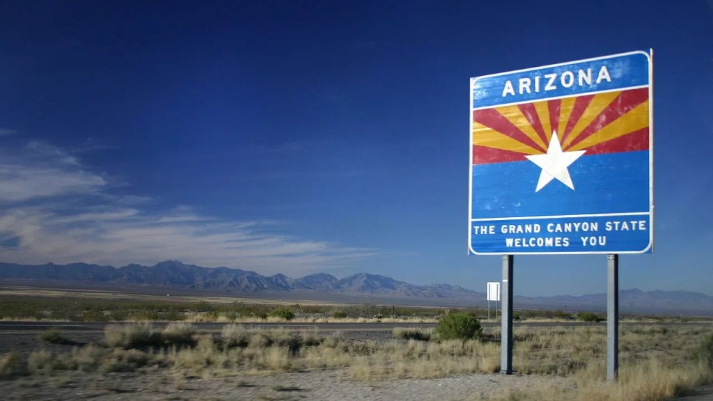 A "Welcome to Arizona" sign on the highway