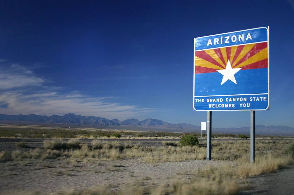 A "Welcome to Arizona" sign on the highway
