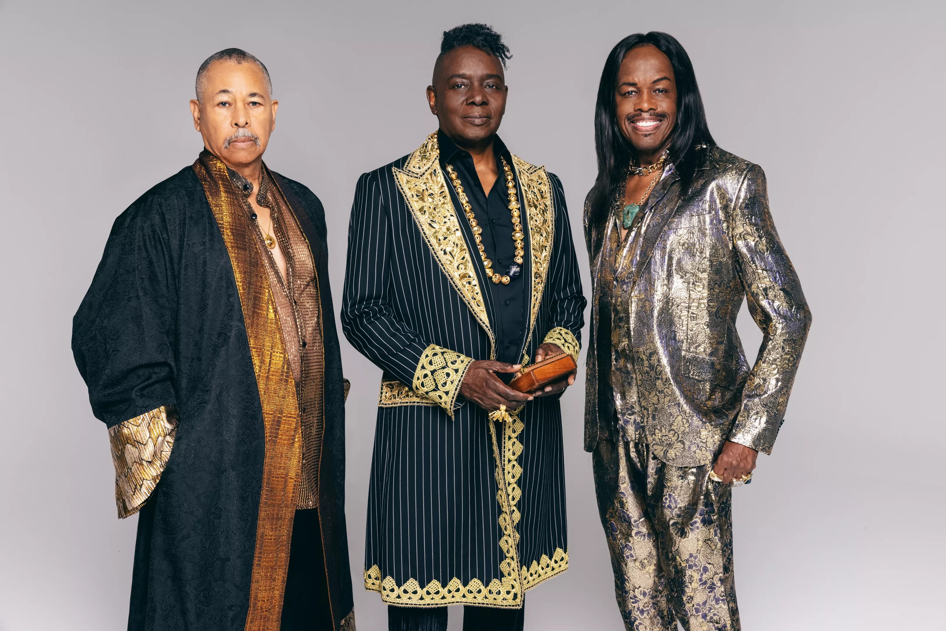 Three Black musicians in stage clothing.