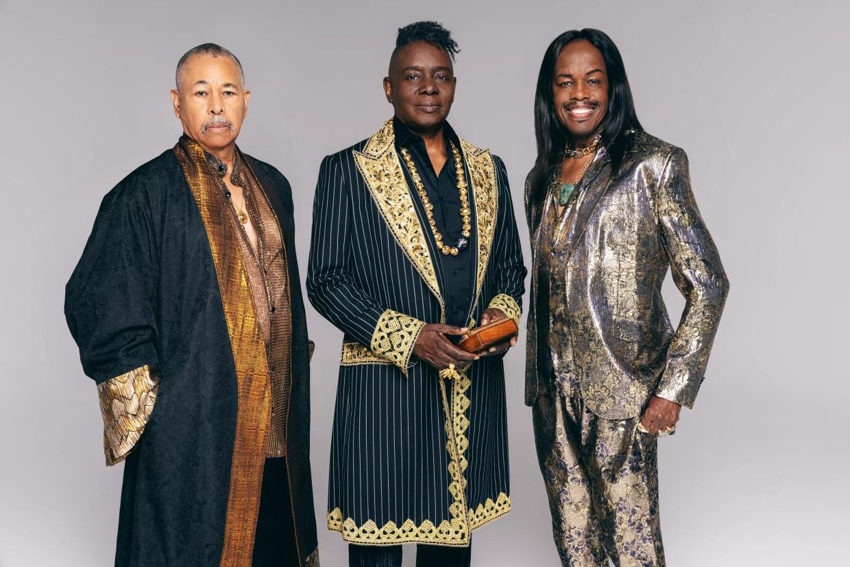 Three Black musicians in stage clothing.