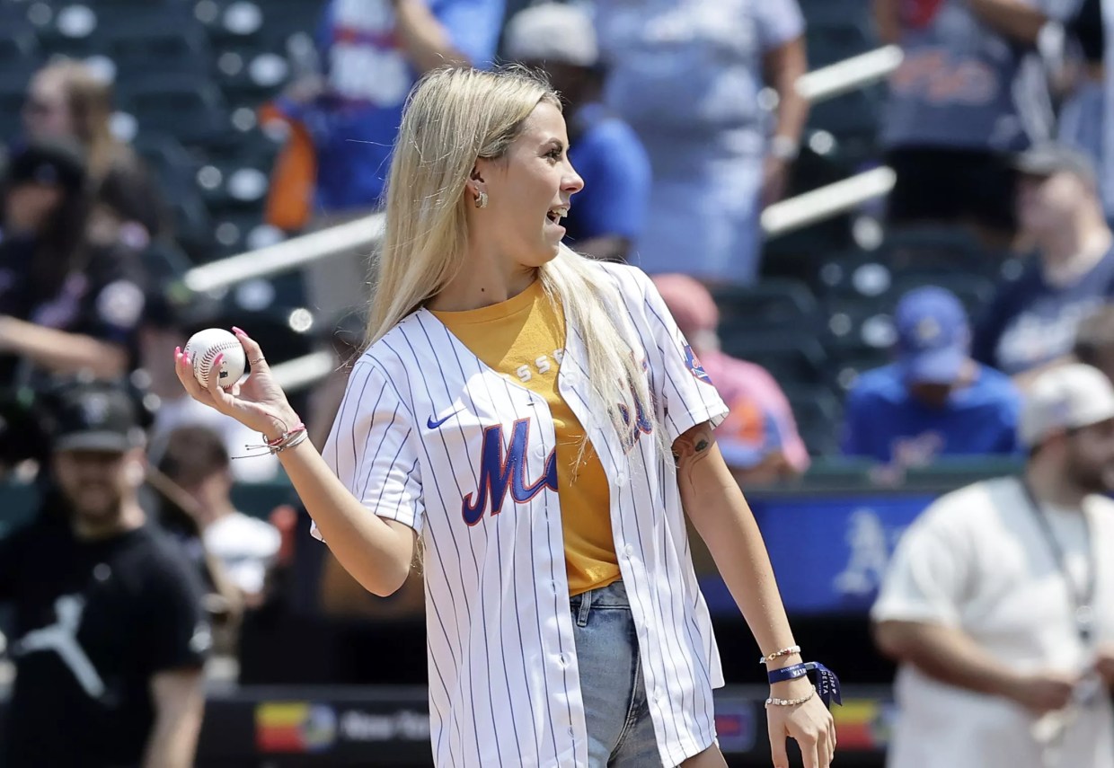 A young blonde woman throwing a baseball.