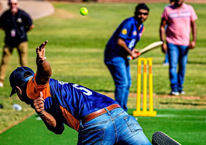 a cricket bowler bowls a ball to a batter