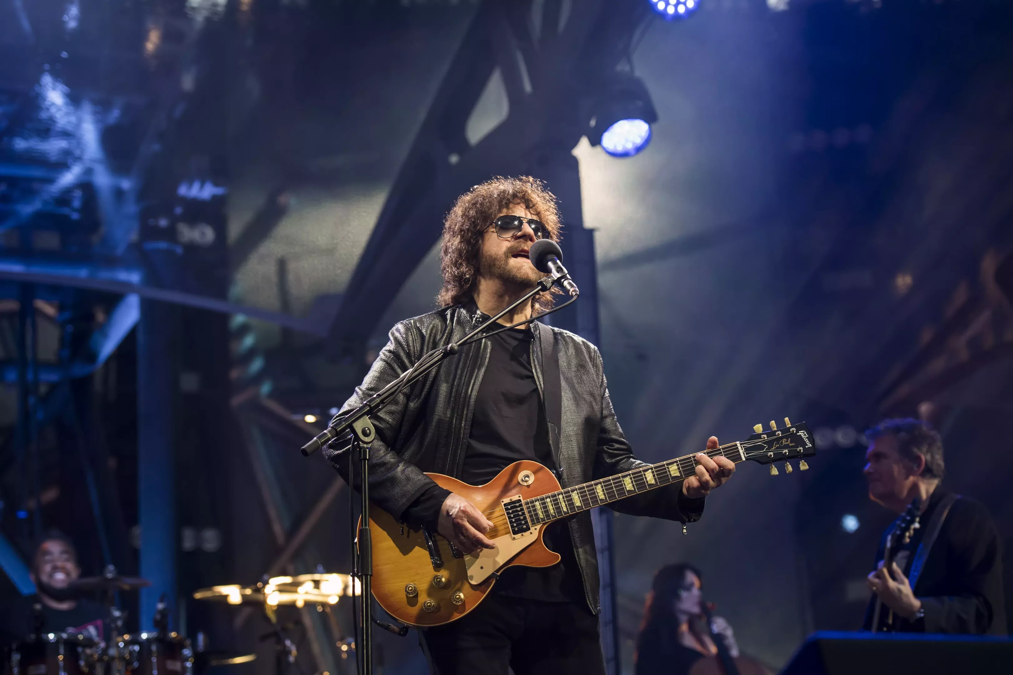 A man with long hair playing the guitar.