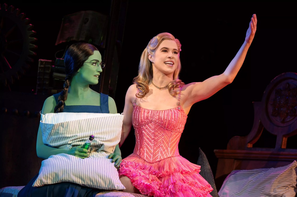 A woman with green skin and a woman in pink dress.