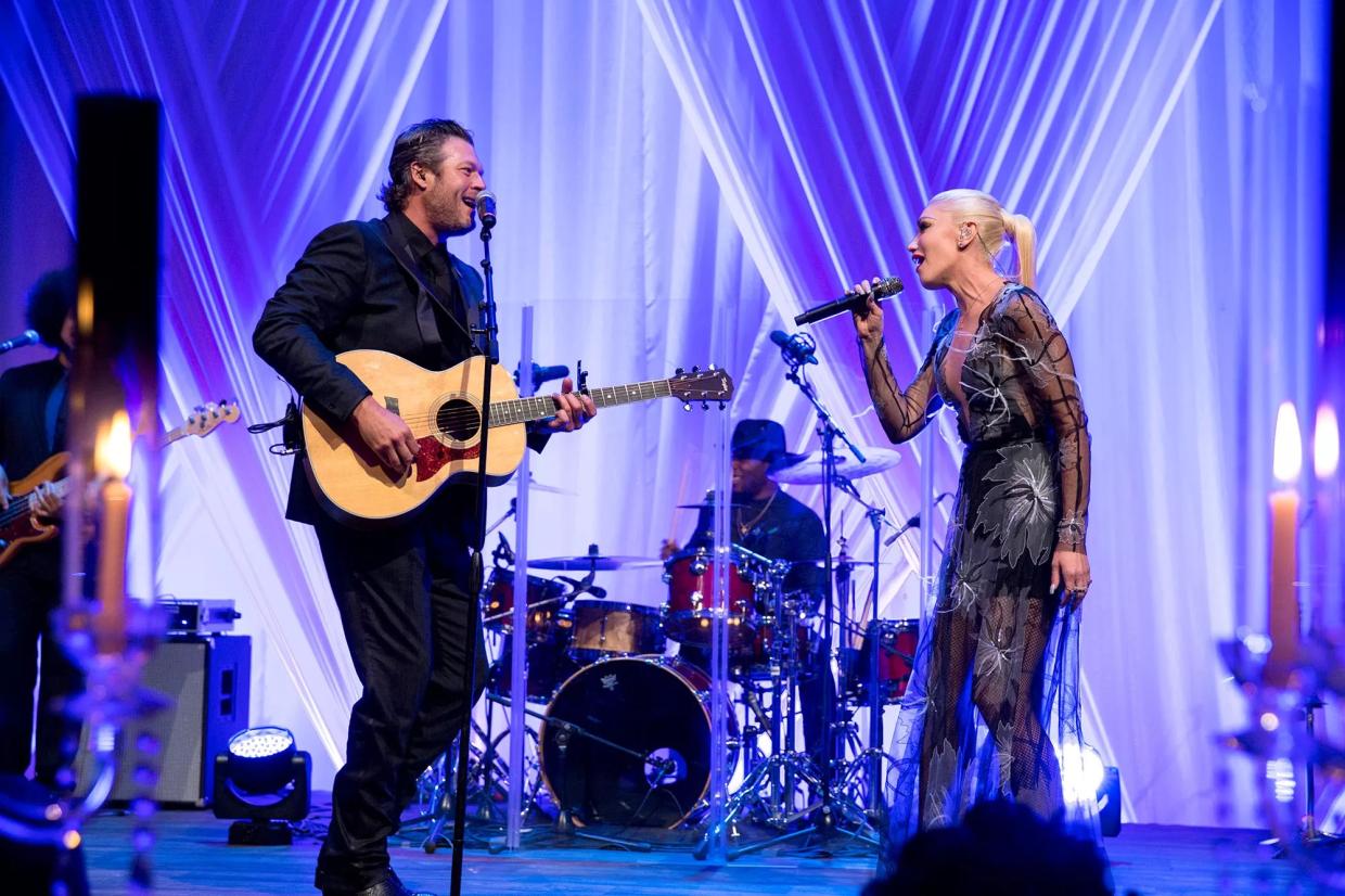 A man and a woman singing together on the stage.