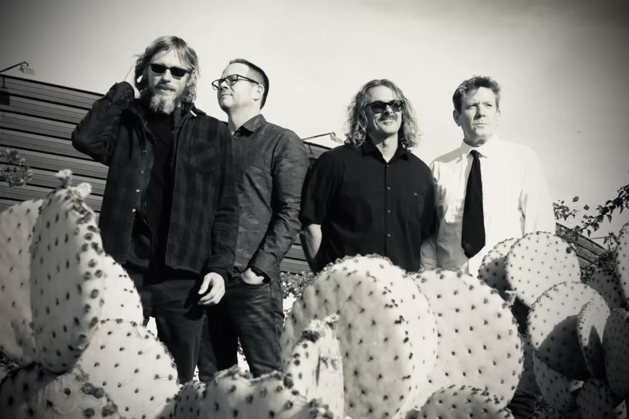 A black and white photo of a rock band.