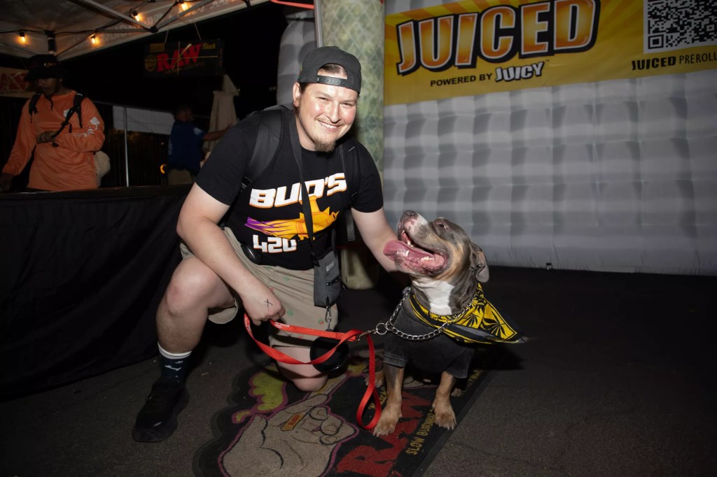 a man poses with a dog