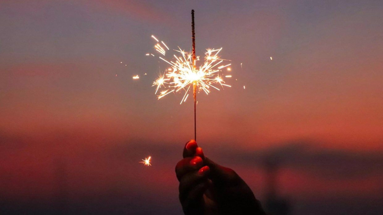 a hand holding a sparkler