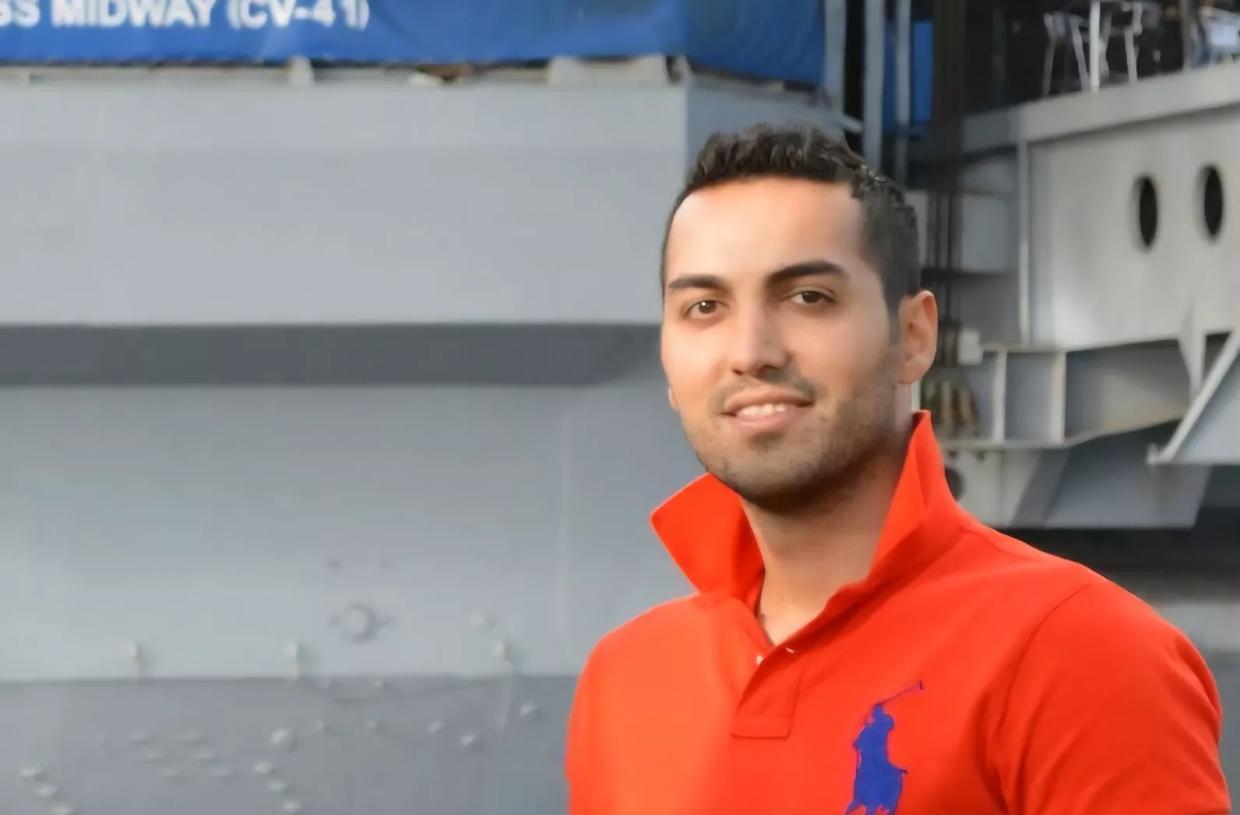 a man in an orange polo shirt with the collar flipped up