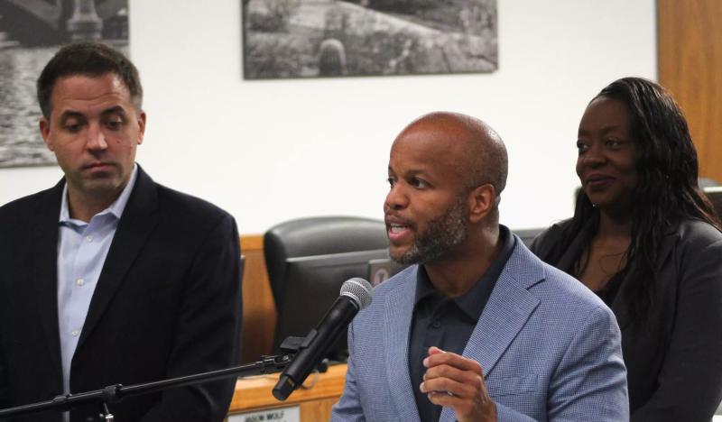 corey woods speaks at a microphone