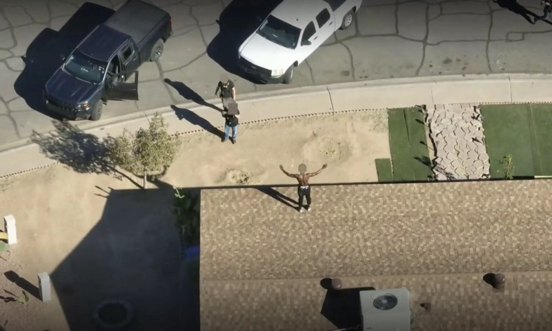 Phoenix police officers aim their weapons at Turrell Clay as he stands on a rooftop with his arms raised in surrender in Maryvale on Jan. 10.