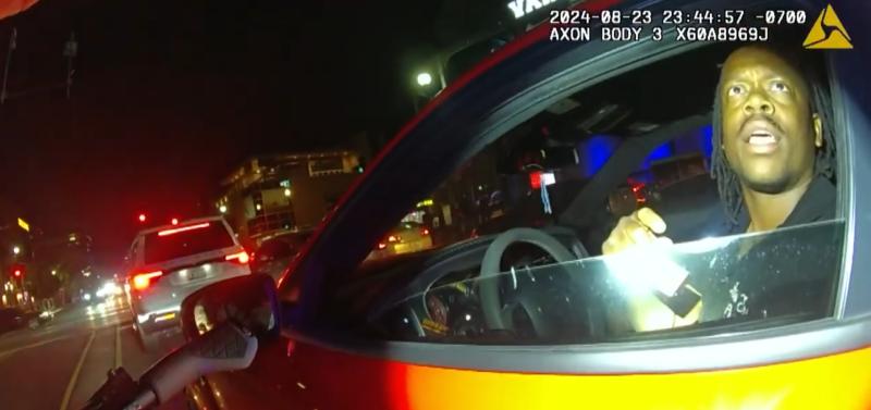 body-cam footage of a flashlight being shined on a man in a car