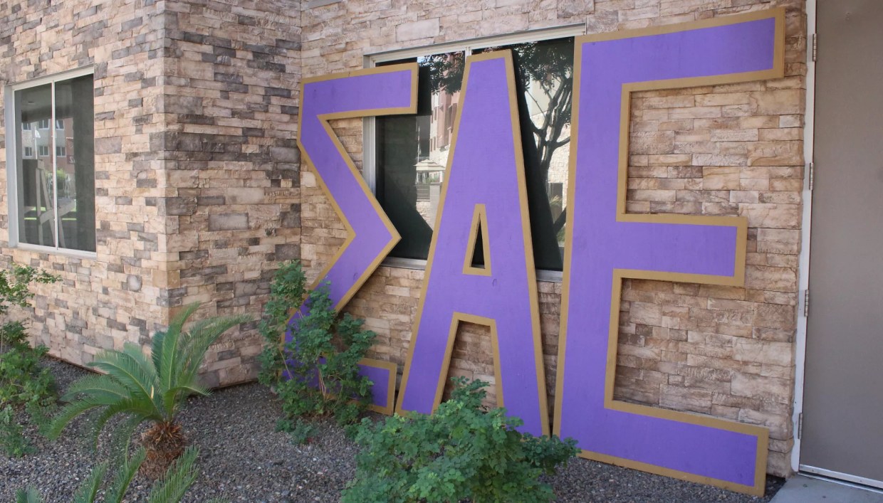 big sigma alpha epsilon letters against a building