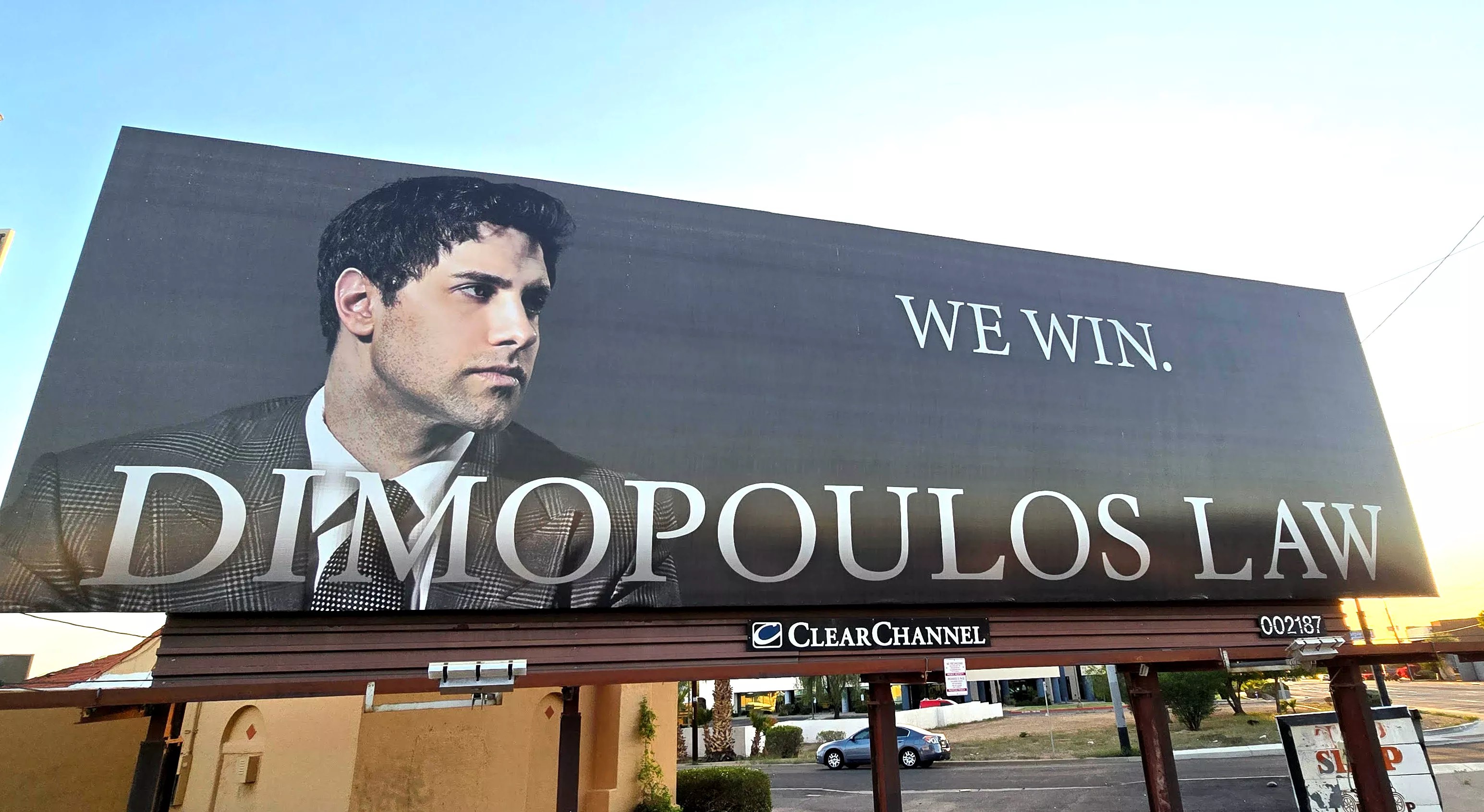 a billboard with a man's face that says 'dimopoulos law: we win"